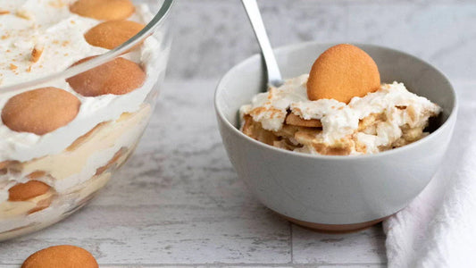 Banana pudding dessert with vanilla wafers in a glass bowl and serving dish, Mora style