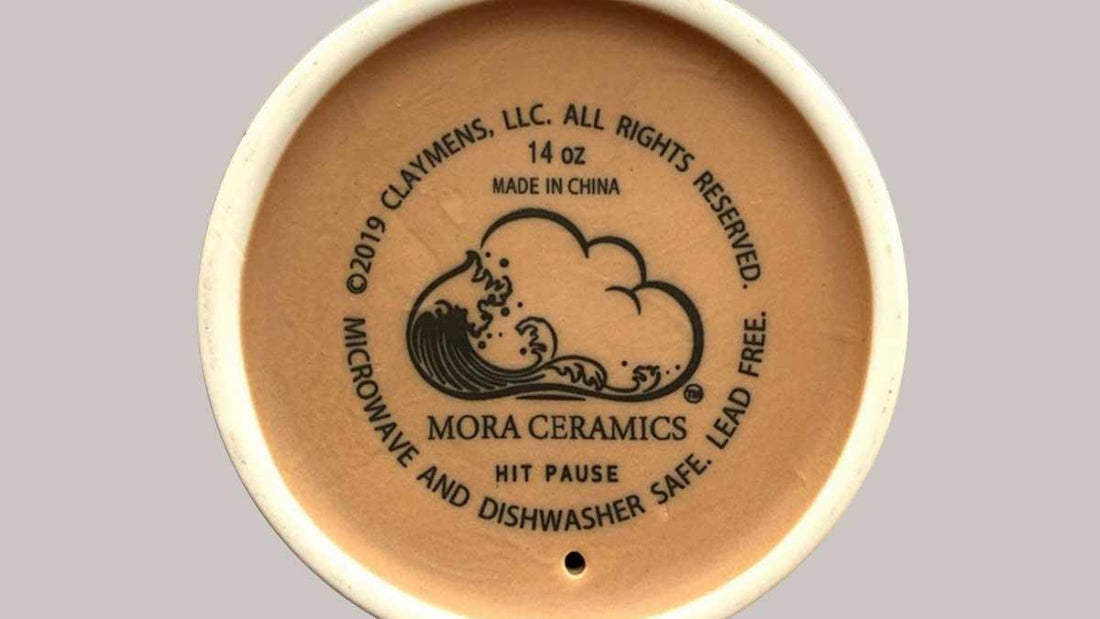 Bottom of a Mora Ceramics mug showing logo, 14 oz size, and dishwasher safe details