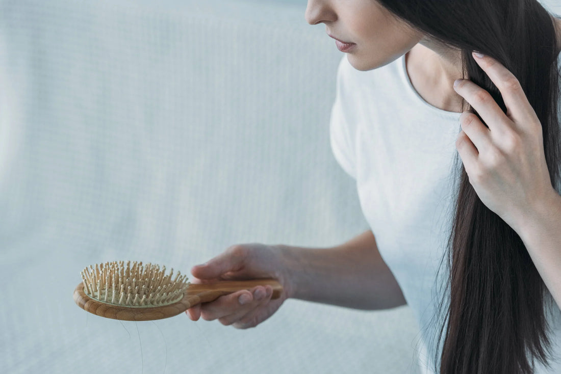 Woman brushing long dark hair with wooden brush, Mora minimalist lifestyle